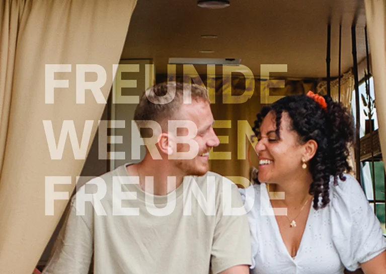 Zwei Freunde sitzen gemeinsam im Wohnmobil – Motiv für das Freunde-werben-Freunde-Programm